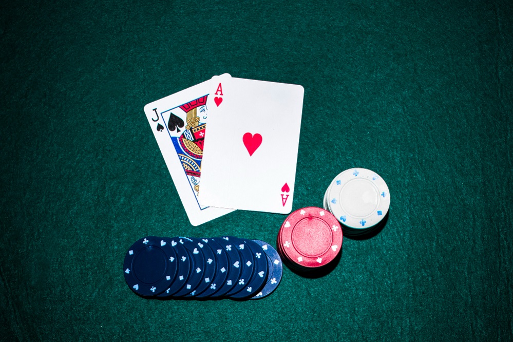 playing cards with casino chips stack on green poker table